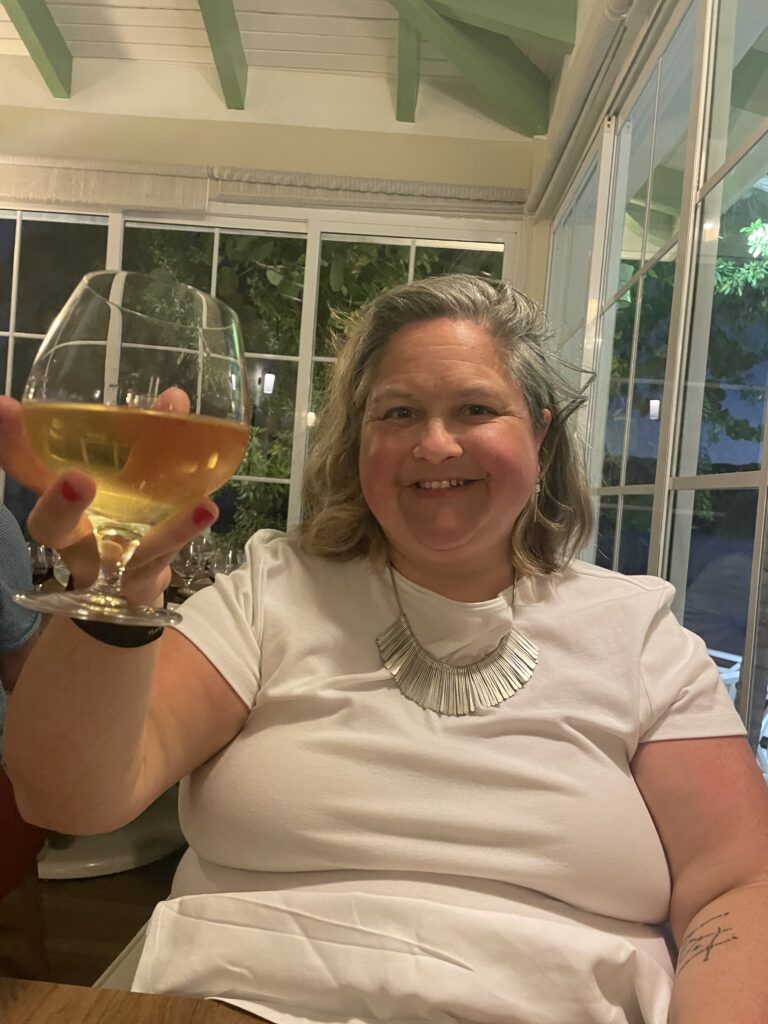 A woman holding up a glass of wine.